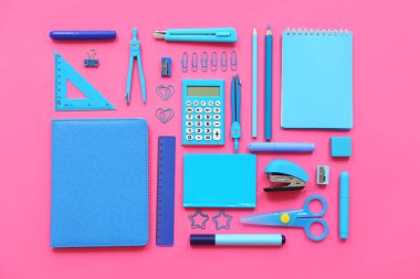 Pembe arka planda not defterleri ve kırtasiye malzemeleri