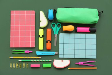 Yeşil arkaplan üzerinde not defterleri ve farklı sayfaları olan kompozisyon