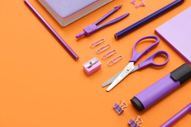 Turuncu arkaplanda farklı kırtasiye malzemeleri, yakın plan