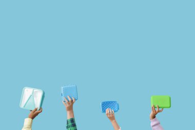 Mavi arka planda okul beslenme çantası olan çocuklar