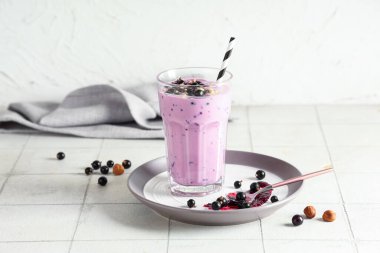 Beyaz fayansların üzerinde siyah frenk üzümlü taze meyve püresi.