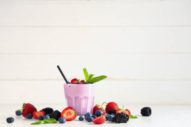 Farklı böğürtlenli taze meyve püresi ve beyaz ahşap arka planda nane şekeri.