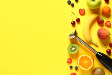 El blenderi ve sarı arka planda taze meyve püresi hazırlamak için farklı malzemeler.