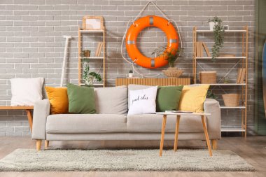 Yüzük şamandırası, raf ünitesi ve kanepesi olan oturma odasının içinde.