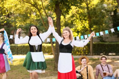 Genç Ekim Festivali garsonları parkta dans ediyor.