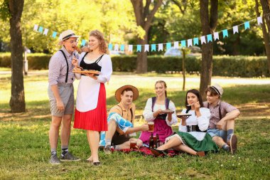 Ekim Festivali garsonu açık havada adama lezzetli sosis veriyor.