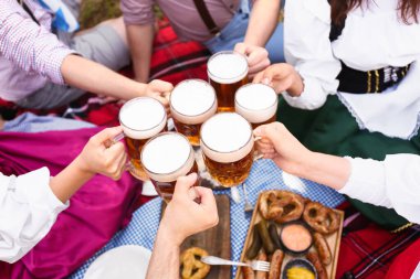 Geleneksel Alman kıyafetleri içinde, bira ve yiyeceklerle genç insanlar Ekim Festivali 'ni açık havada kutluyorlar.