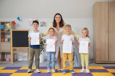 Sayıları olan küçük çocuklar ve anaokulunda anaokulu öğretmeni.