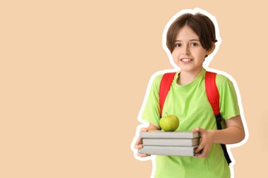 Sırt çantası, kitapları ve bej arka planda elması olan küçük okul çocuğu.