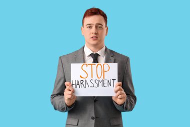 Elinde mavi zemin üzerinde DUR yazan kağıt tutan genç işadamı