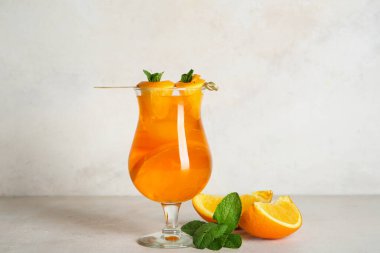 Bir bardak lezzetli yaz kokteyli ve portakallı ışık masası.