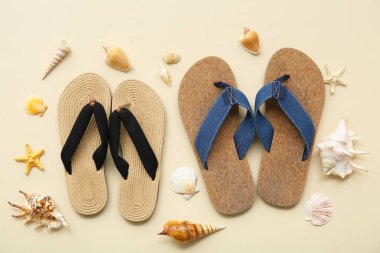 Renkli arka planda şık parmak arası terlikleri ve farklı deniz kabukları olan kompozisyon