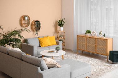 Rahat kanepesi, sehpası, çekmeceleri ve perdeleri olan şık bir oturma odası.