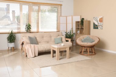 Rahat kanepesi, koltuğu, sehpası ve katlanır ekranı olan şık bir oturma odası.