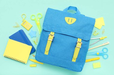 Okul sırt çantalı kompozisyon ve renk arkaplan üzerinde farklı kırtasiye