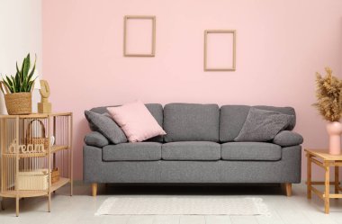 Rahat kanepesi, çekmecesi ve saksısı olan şık bir oturma odası.