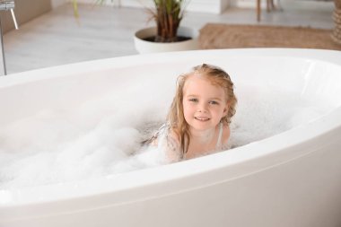 Köpüklü şirin kız banyoda banyo yapıyor.