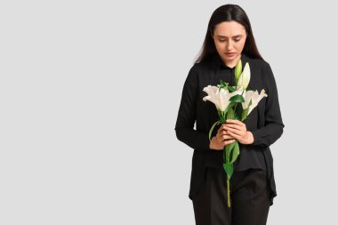 Beyaz arka planda bir buket nilüfer çiçeği olan genç bir kadın.