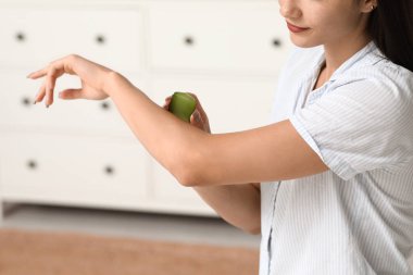 Güzel genç bir kadın banyoda aloe vera kullanıyor.