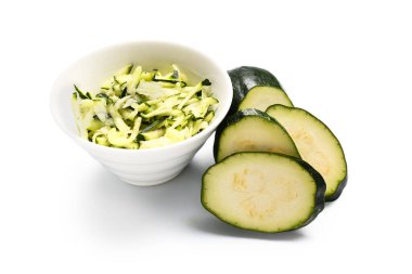 Beyaz arka planda taze yeşil kabak dilimleri ile kase