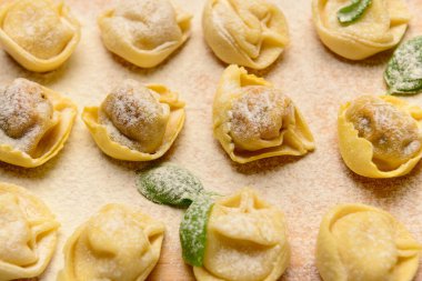 Ahşap arka planda çiğ hamur köftesi ve fesleğen, yakın plan.