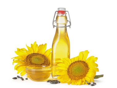 Beyaz arka planda tohumları olan bir şişe ve cam ayçiçeği yağı.