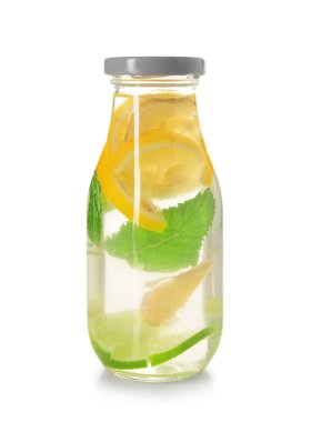 Beyaz arka planda zencefilli ve limonlu bir şişe lezzetli limonata.