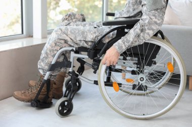 Evde tekerlekli sandalyedeki genç asker