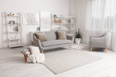 Koltuğu, koltuğu ve raf ünitesi olan bir oturma odası.