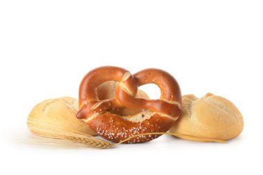 Different delicious kaiser rolls, pretzel and wheat ear on white background clipart