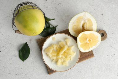 Tabak ve sepette beyaz arka planda taze nar meyveleri var.