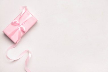 Beyaz arka planda pembe kurdeleyle bağlanmış hediye kutusu. Üst görünüm