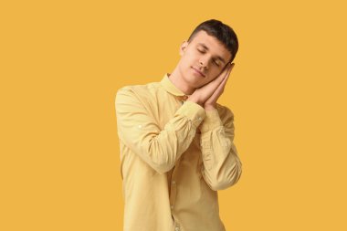 Sarı arka planda işaret dili kullanan genç sağır ve dilsiz adam.