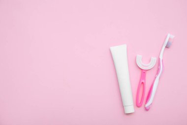 Pembe arka planda diş macunlu diş fırçaları