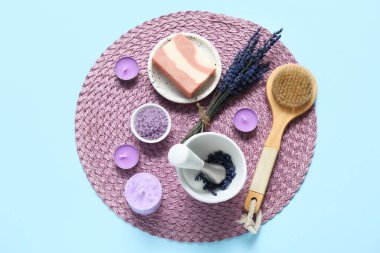 Havan, hasır ve mavi arkaplanda mumlarla lavantalı güzel bir kompozisyon.