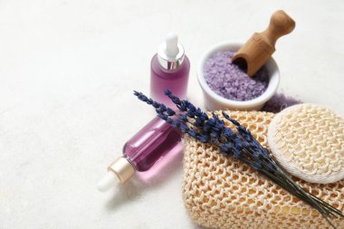 Açık arkaplanda lavanta yağı, banyo süngeri ve deniz tuzu içeren güzel bir kompozisyon, yakın plan.