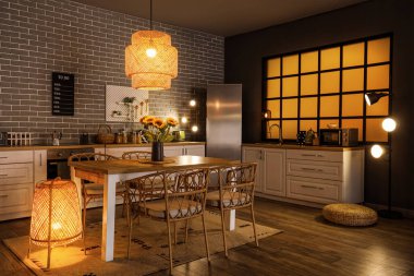 Modern mutfak, yemek masası, tezgah ve buzdolabı.