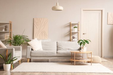 Gri kanepeleri ve çiçekleri olan modern bir oturma odası.