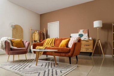 Koltuk ve koltuk. Oturma odasında ekose ve minder var.