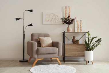 Koltuk, raf ünitesi ve oturma odasındaki duvarda resimler.