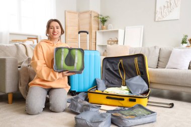 Evde boyun yastığı paketleyen genç bir kadın. Seyahat kavramı