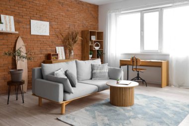 Oturma odasının içinde kanepe, sandalyeli masa ve duvarda resimler var.