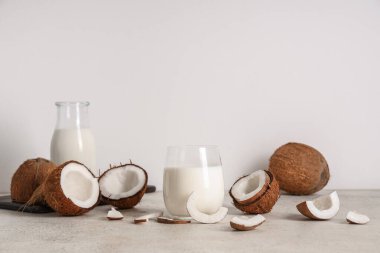 Hafif arka planda bir şişe ve bir bardak lezzetli hindistan cevizi sütü