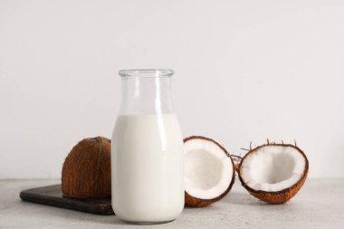 Hafif arka planda bir şişe lezzetli hindistan cevizi sütü.