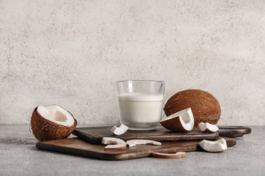 Bir bardak lezzetli hindistan cevizi sütü ve ahşap kesme tahtaları.