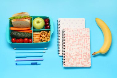 Okul malzemeleri, üzerinde sandviç ve muz olan beslenme çantası. Üst görünüm
