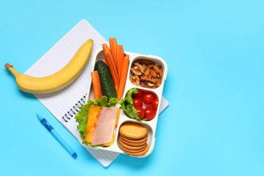 Okul malzemeleri, üzerinde sandviç ve muz olan beslenme çantası. Üst görünüm