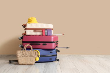 Bej duvarın yanında şapka ve pasaportlarla dolu bavullar.
