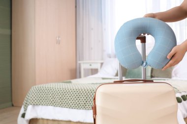 Bavulun yanında boyun yastığı olan bir kadın. Seyahat kavramı