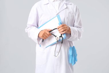 Gri arkaplan ve steteskoplu erkek tıp öğrencisi, yakın plan.